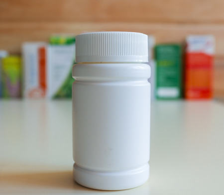 Jar with airtight lid for storing pills and ointments.Drugs in the blur in the background.の写真素材