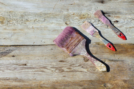 Used brush on wooden background. Repair, painting, updating the interior. Accessories for paint. Services, paint, brush. The place to advertise.の写真素材
