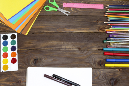 The concept of education. The view from the top. School and office supplies on dark wooden background with place for your text or advertising .Stationery, school accessories.の写真素材