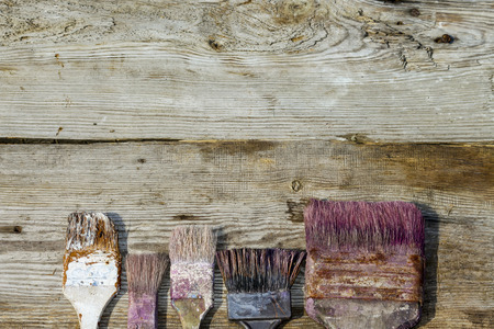 Used brush on wooden background. Repair, painting, updating the interior. Accessories for paint. Services, paint, brush. The place to advertise.の写真素材