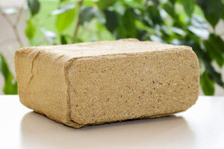 Alternative fuel, eco fuel, bio fuel. Wood sawdust briquettes for stoves. Lean-burn with good heat output. Briquettes from sawdust on a green background.の写真素材
