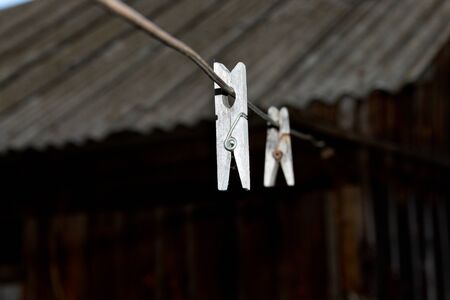 Old wooden clothespins for linen on the wire.の写真素材