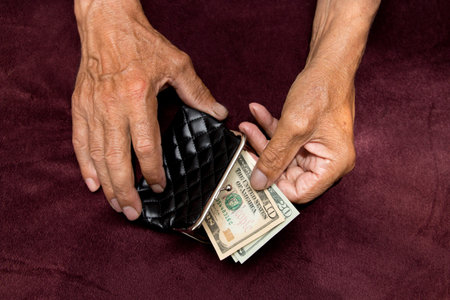 Elderly man puts money in the wallet.