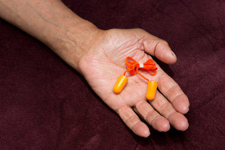 Earplugs In the hands of an elderly man.