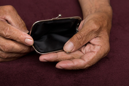 An elderly man holds an empty purse. The concept of poverty in retirement .の写真素材