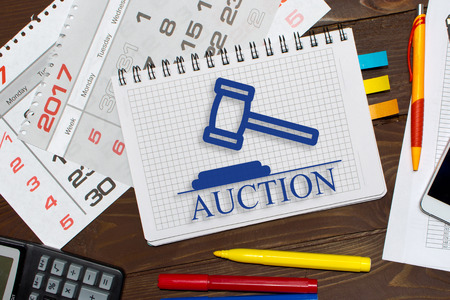 Notebook with a notes online auctions  on the office table with tools.の写真素材