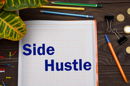 Notebook with a notes Side Hustle on the office table with tools. Business conceptの写真素材