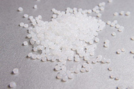 Polypropylene transparent granules on the grey background.