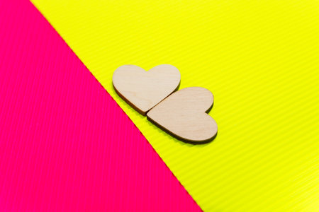 Two Hearts on the two-tone corrugated cardboard background. Yellow and pink trendy colors. Abstract...