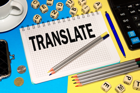 Notebook with Notes TRANSLATE with office tools and dice with letters . Concept TRANSLATEの写真素材