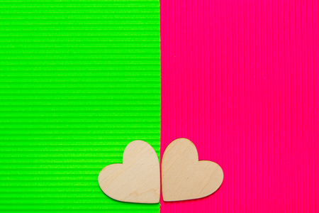 Two Hearts on the two-tone corrugated cardboard background. Green and pink trendy colors. Abstract geometric background. Valentine's day background.の写真素材