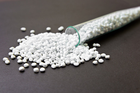 Plastic pellets. White Colorant for plastics on a dark background. Plastic Raw material .の写真素材