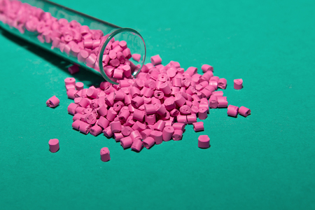 Plastic pallets . Plastic raw materials in granules for industry. Polymeric dye pink on a turquoise background. Plastic granules after processing of waste polyethylene and polypropylene.Polymer.の写真素材