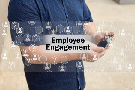 Employee Engagement   on the touch screen with a blur background of the businessman with the phone.The concept of Employee Engagement の写真素材