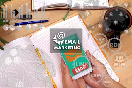 EMAIL MARKETING on the touch screen to the network, on office blur background.Concept of EMAIL MARKETINGの写真素材