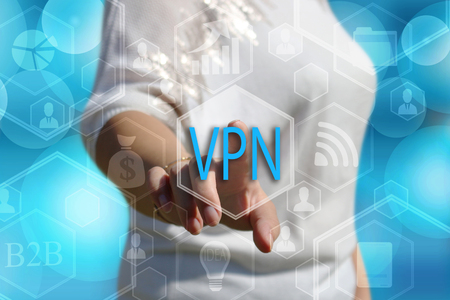 The businessman chooses button VPN, Virtual Private Network on the touch screen with a futuristic backgroundの写真素材