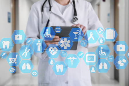 Medical network connection on the virtual touch screen and Doctor with stethoscope in hospital background.Technology and medicine concept.の写真素材