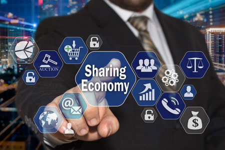 The businessman chooses the Sharing Economy  on the virtual screen in the business network connection.の写真素材