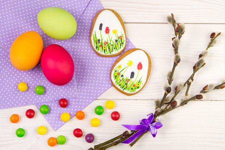 Easter background with Easter eggs and a willow twig. Easter gingerbread, eggs and willow twig on...