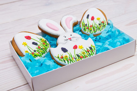 Easter gingerbread set in a box on white wooden background.  Easter Bunny and eggs.