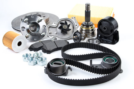 Auto parts background. Hub, pump, brake pads, filter, timing belt, rollers, constant velocity joints, thermostat and other on white background. Set of spare parts for repairの写真素材