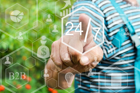 Farmer pressing 24 hours 7 days web service icon on a virtual screen.