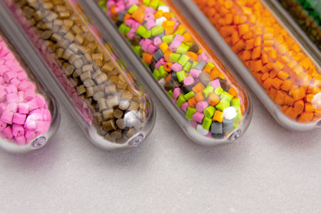 Plastic pellets. Polymeric dye in test tubes on gray background.の写真素材