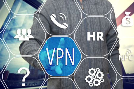 The businessman chooses button VPN, Virtual Private Network on the touch screen with a futuristic backgroundの写真素材