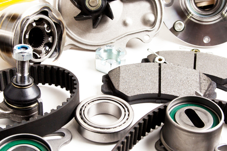 Auto parts background. Hub, pump, brake pads, filter, timing belt, rollers, constant velocity joints, thermostat and other on white backgroundの写真素材
