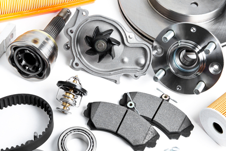 Auto parts background. Hub, pump, brake pads, filter, timing belt, rollers, constant velocity joints, thermostat and other on white backgroundの写真素材
