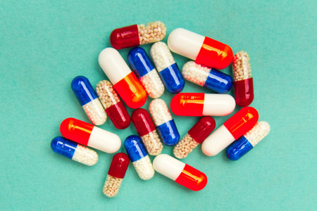 capsules (pills) on a turquoise background. Medical background, template.