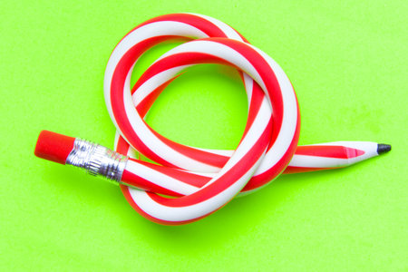 Flexible pencil on a yellow background. Bent pencils two-color