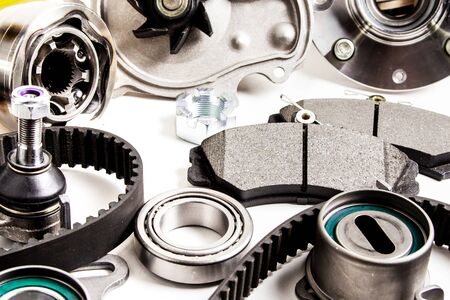 Auto parts background. Hub, pump, brake pads, filter, timing belt, rollers, constant velocity joints, thermostat and other on white backgroundの写真素材