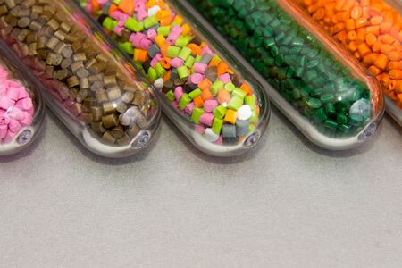 Plastic pellets .Polymeric dye in test tubes on gray background.の写真素材