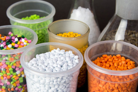 Plastic granules in a measuring container and test tubes in the laboratory. Plastic pellets. Plastic...