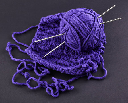 A piece of purple knitting, against a dark backgroundの写真素材