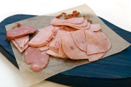 Boiled sausage slices on blue wooden board. Selective focus.