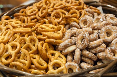 Salty pretzels close-up in wicker basket, top view. Oktoberfest mini pretzel, beer snack.の写真素材