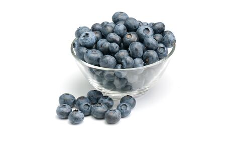 Fresh wild blueberries in glass bowl isolated on white background.の写真素材