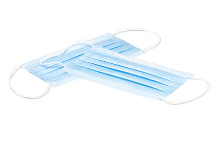 Two blue medical face masks isolated on white background. Surgical protective masks close-up.の写真素材