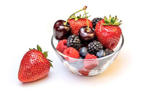 Fresh different berries in glass bowl isolated on white background.の写真素材