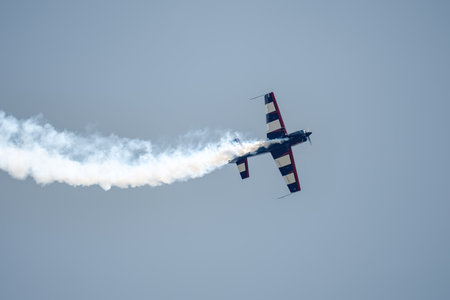 Kubinka, Moscow Region, Russia - May 12, 2021: Silhouette of an airplane with trail of smoke behind against background of blue sky. Air show background.のeditorial素材