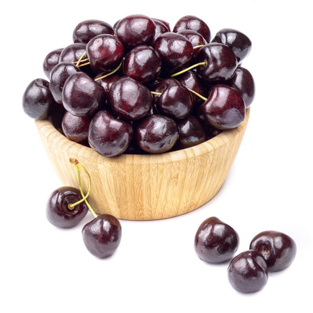 Sweet cherry berries in wooden bowl isolated on white background.の写真素材