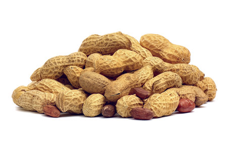 Heap of peanuts closeup isolated on white background.