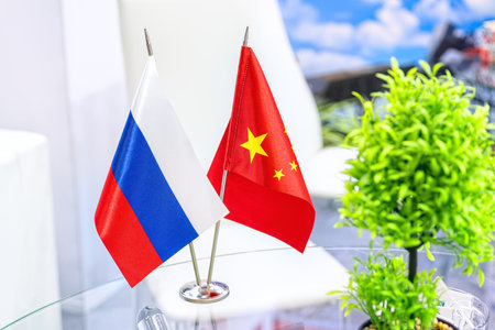 Russian and Chinese flags on glass table in meeting room. The concept of Russian Chinese cooperation.の写真素材