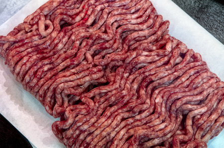 Fresh raw minced meat on paper, pork, beef, forcemeat close-up isolated on white background, top view.の写真素材