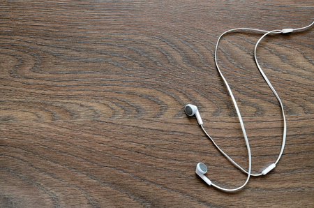 White earphones on wooden boardの写真素材
