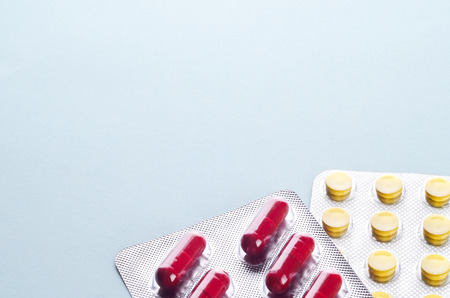 Assorted colorful pills and capsules in a Blister packaging on a light background close up, horizontal, copy space, selective focus, medical concept.の写真素材