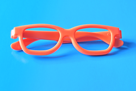 Flat lay fashion set: sunglasses on pastel backgrounds. Fashion summer is coming concept. Orange glasses on a blue background, top view. Trendy colorful photo. Minimal style with colorful paper backdrop.の写真素材