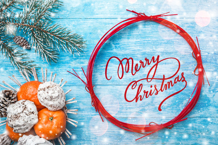 Azure wood background. Green fir tree. Fruit with mandarin and sweets. Red Circle for Christmas Message or New Year. Space for Santa's message. Xmas and Happy New Year composition. Flat lay, top viewの写真素材